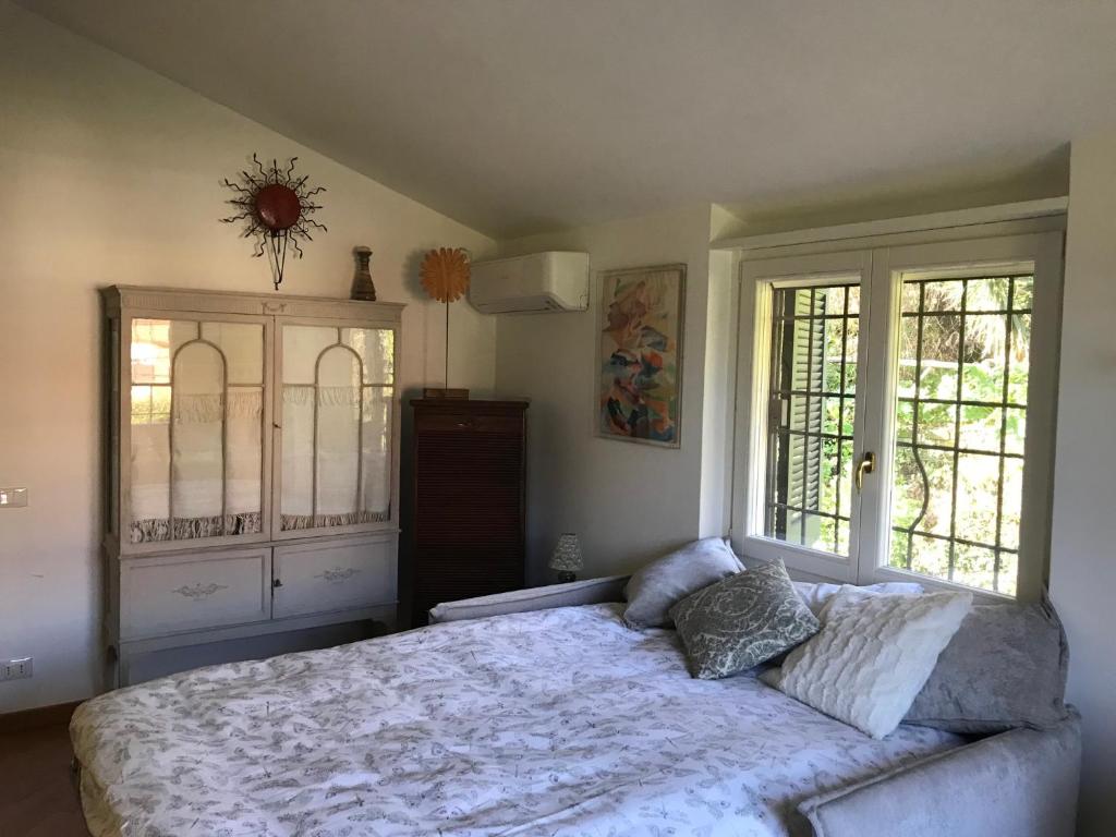 une chambre avec un grand lit et deux fenêtres dans l'établissement Deliziosa Villa alle porte di Roma, à Sacrofano