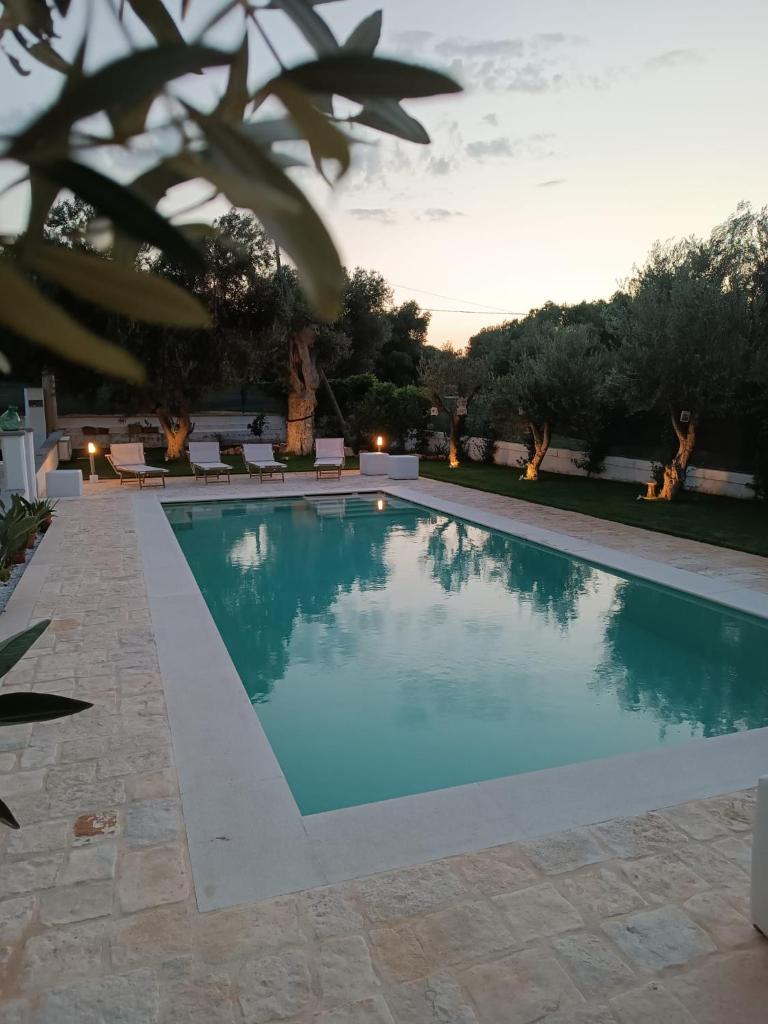 une piscine avec un coucher de soleil en arrière-plan dans l'établissement Il Vecchio Carrubo - Villa con piscina a sfioro, à Macchia di Monte