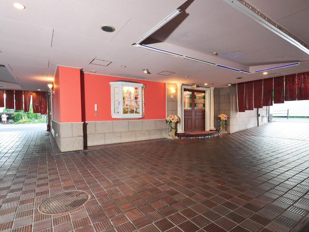 une pièce vide avec des murs rouges et une piste de danse dans l'établissement Roselips Tsuruhashi ローズリップス鶴橋adult only, à Osaka