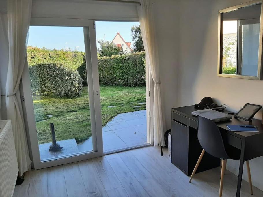 un bureau avec un bureau et une porte coulissante en verre dans l'établissement Gite Troubadour - Cap Gris Nez - piscine, à Audinghen