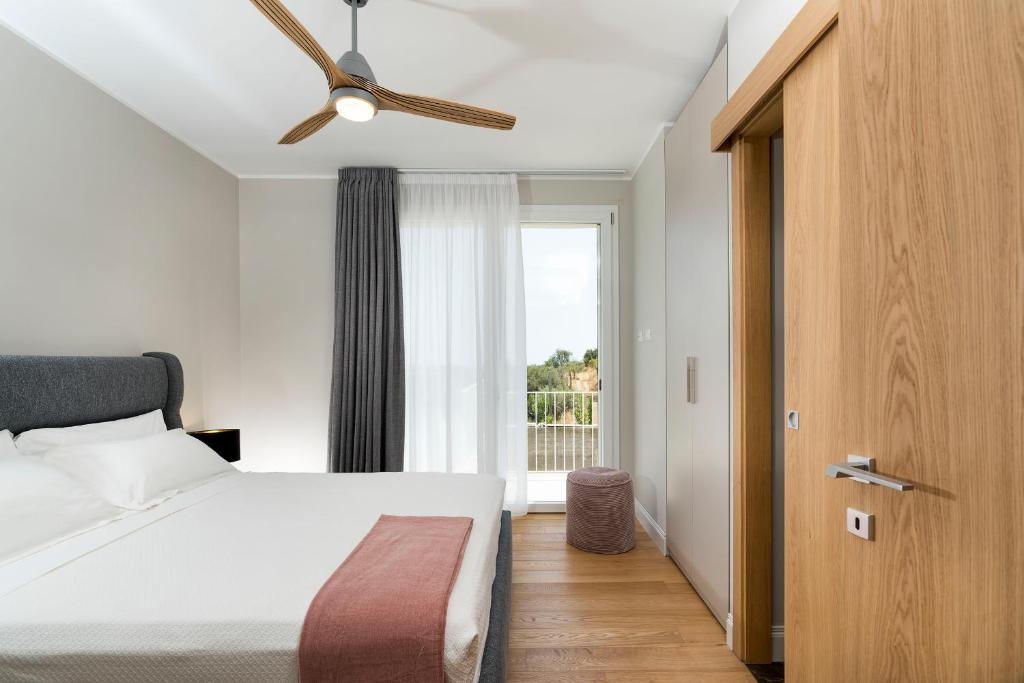 - une chambre avec un lit, un ventilateur de plafond et une fenêtre dans l'établissement ColleVerde, à Noto