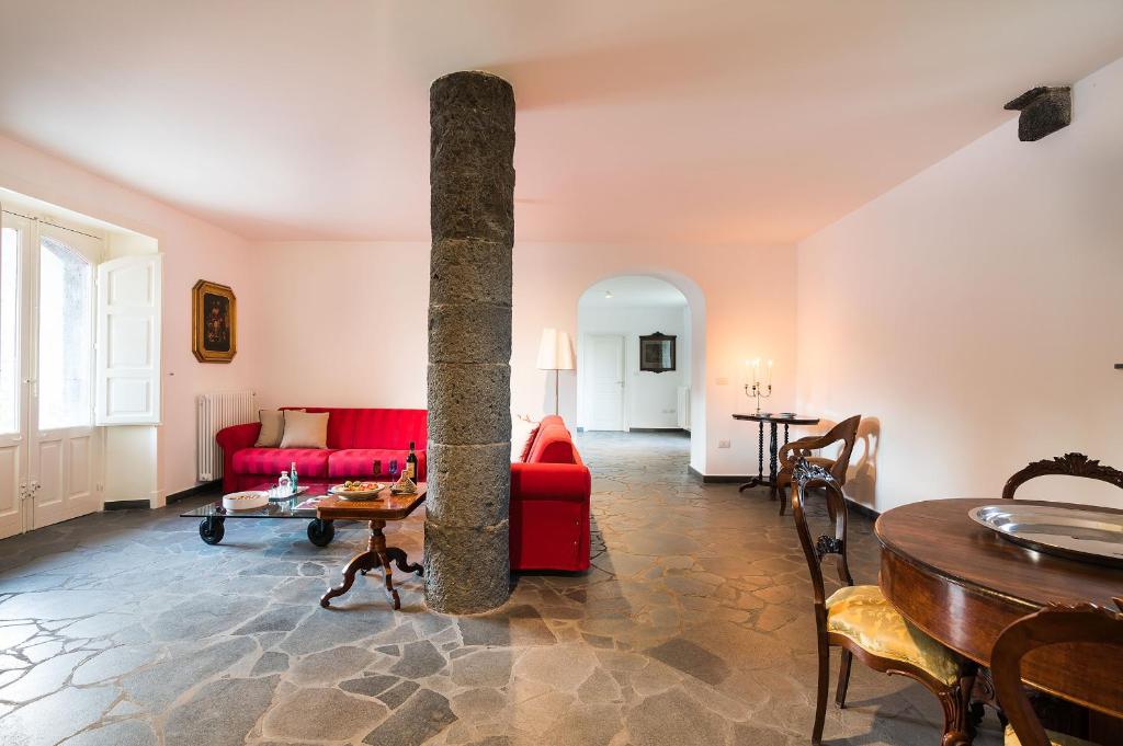 un salon avec un canapé rouge et une table dans l'établissement Etna Retreat, à Castiglione di Sicilia