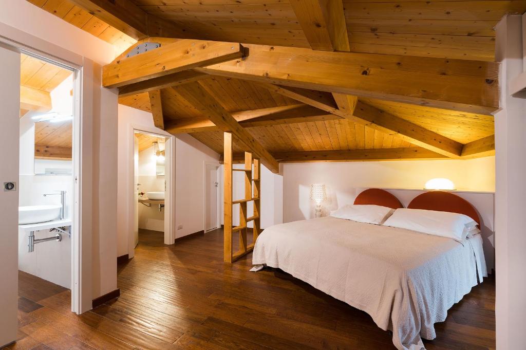 - une chambre avec un grand lit et des plafonds en bois dans l'établissement Etna Retreat, à Castiglione di Sicilia