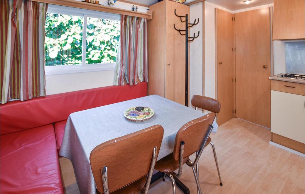 - une salle à manger avec une table et un canapé rouge dans l'établissement Pet Friendly StaCaravan, à Entraigues-sur-la-Sorgue