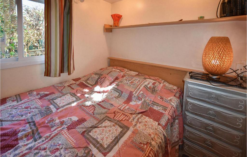 - une chambre avec un lit, une lampe et une commode dans l'établissement Pet Friendly StaCaravan, à Entraigues-sur-la-Sorgue