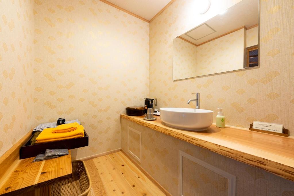 une salle de bain avec un lavabo et un miroir dans l'établissement Ryoan Fukinotou, à Bungotakada