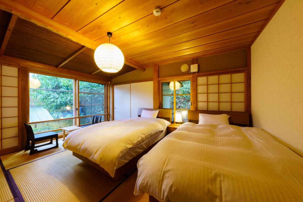 une chambre avec deux lits dans une pièce dans l'établissement Ryoan Fukinotou, à Bungotakada
