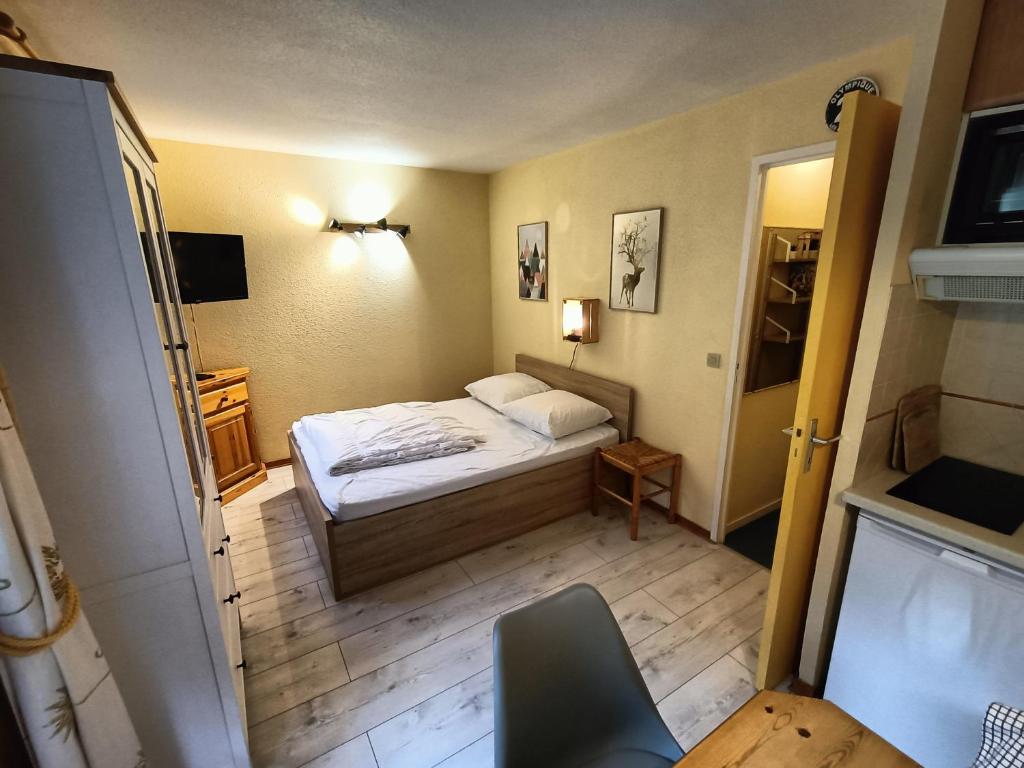 une petite chambre avec un lit et une table dans l'établissement Nice & cozy apartment facing the gondola - LA BOULE DE NEIGE 112, aux Contamines-Montjoie