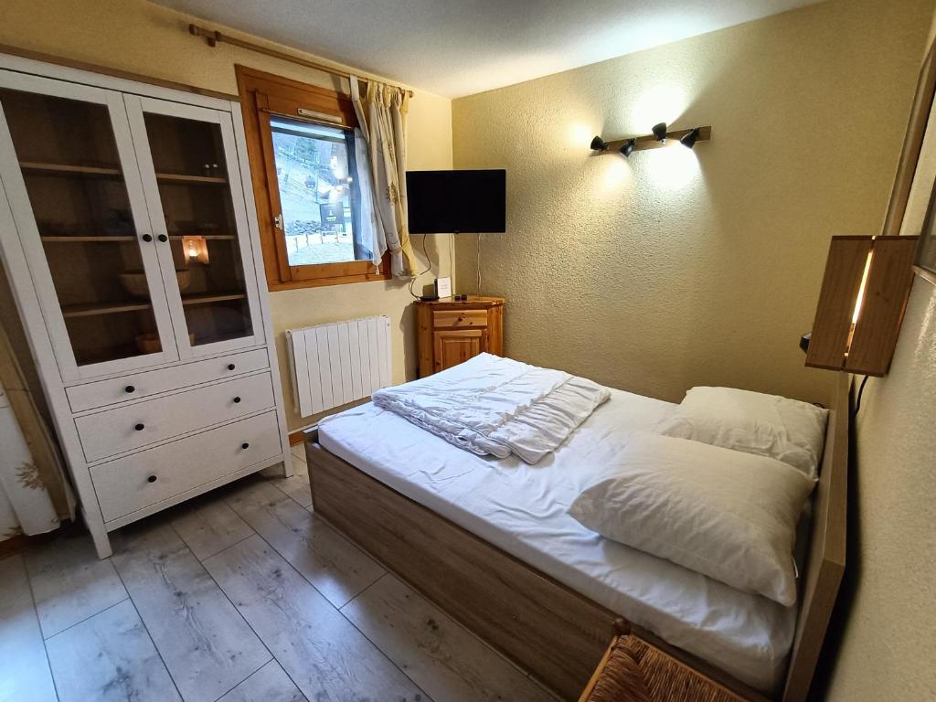 une petite chambre avec un lit et une fenêtre dans l'établissement Nice & cozy apartment facing the gondola - LA BOULE DE NEIGE 112, aux Contamines-Montjoie