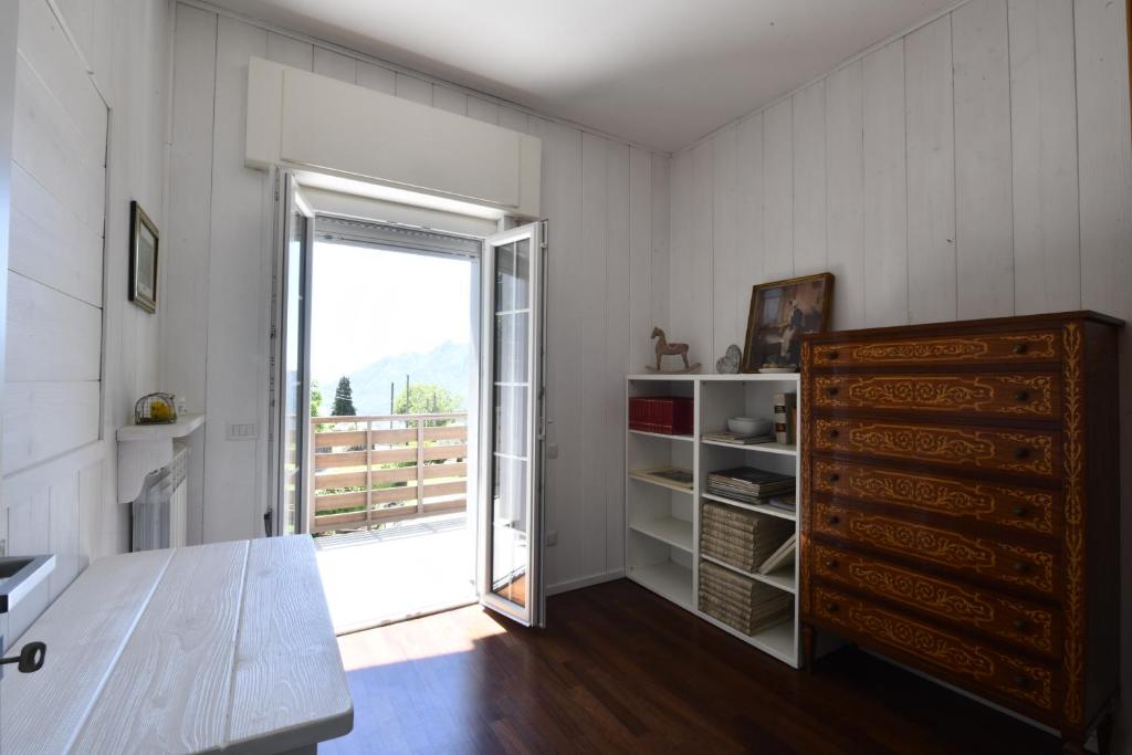 Cette chambre dispose d'une porte s'ouvrant sur un balcon. dans l'établissement ANGEL'S VILLA - Panoramic LAKE VIEW, à Lecco