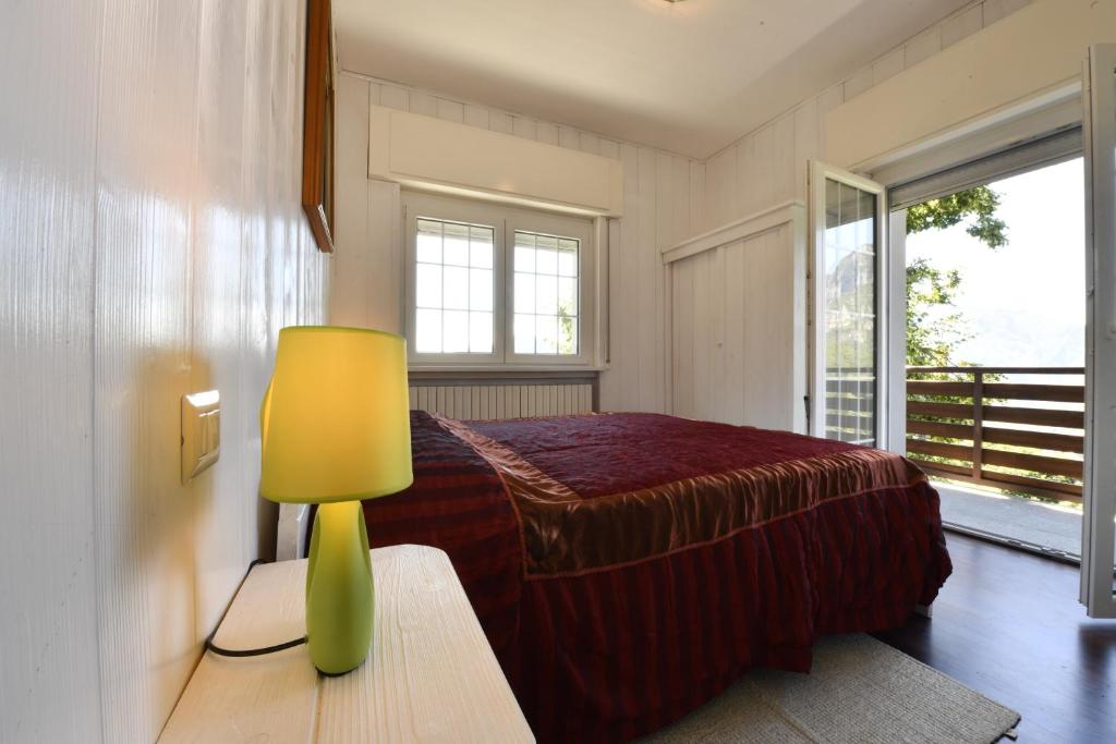 une chambre avec un lit et une lampe sur une table dans l'établissement ANGEL'S VILLA - Panoramic LAKE VIEW, à Lecco