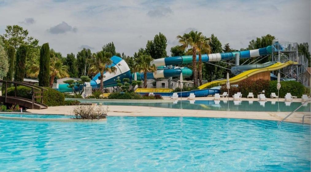 un parc aquatique avec un toboggan en arrière-plan dans l'établissement Mobile-home La Carabasse FO88, à Vias