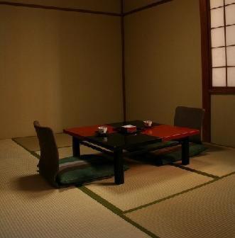 une chambre avec une table, deux chaises et une table rouge dans l'établissement Kikunoya Ryokan, à Kanazawa
