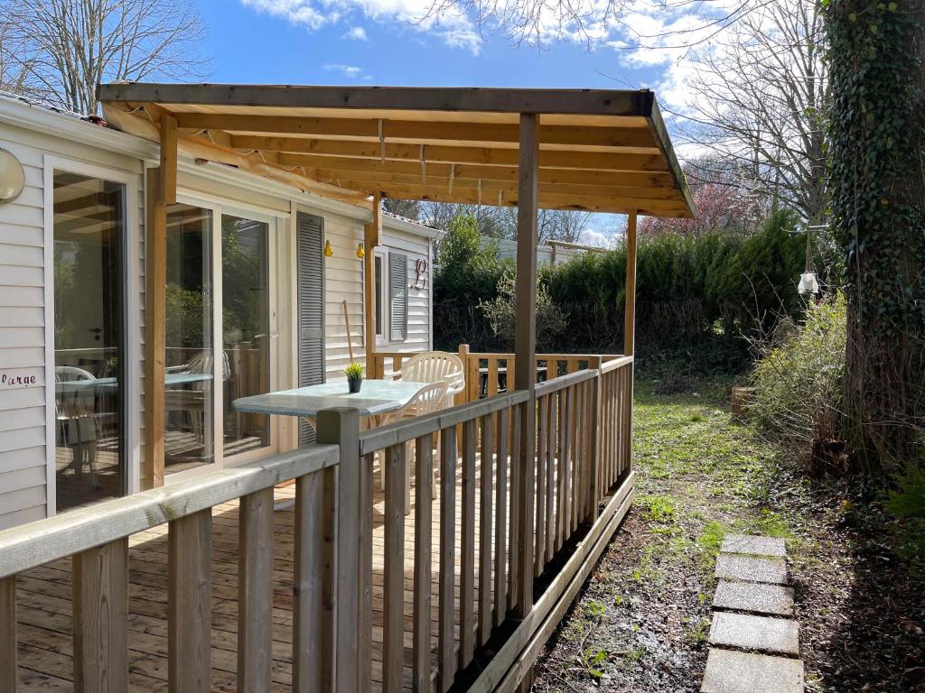une terrasse en bois avec pergola sur une maison dans l'établissement Bungalow climatisé dans un bel écrin de nature, à Saint-Chéron 14 autres photos