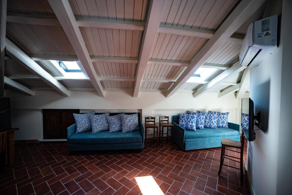 - deux canapés bleus dans une chambre avec lucarnes dans l'établissement Villa con Piscina Privata a 2 kilometri da Tropea, à Gasponi