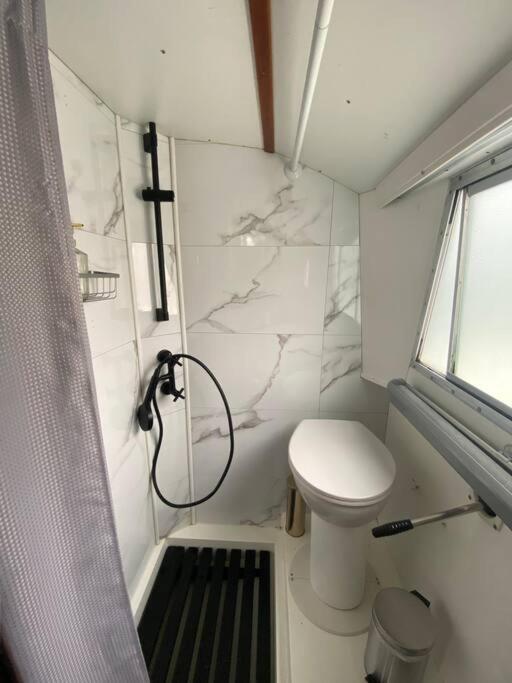 une petite salle de bain avec toilettes et douche dans l'établissement Charmant bateau sur la Marne, à La Ferté-sous-Jouarre
