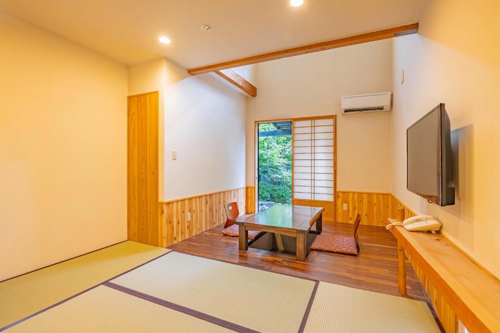 un salon avec une table et une télévision dans l'établissement Sengokuhara Shinanoki Ichinoyu, à Hakone