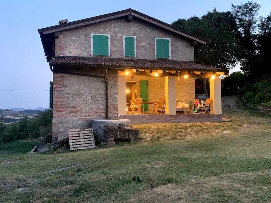 une petite maison en pierre sur une colline avec un grill dans l'établissement Casale IL SAMBUCO sui colli bolognesi, à San Lazzaro di Savena
