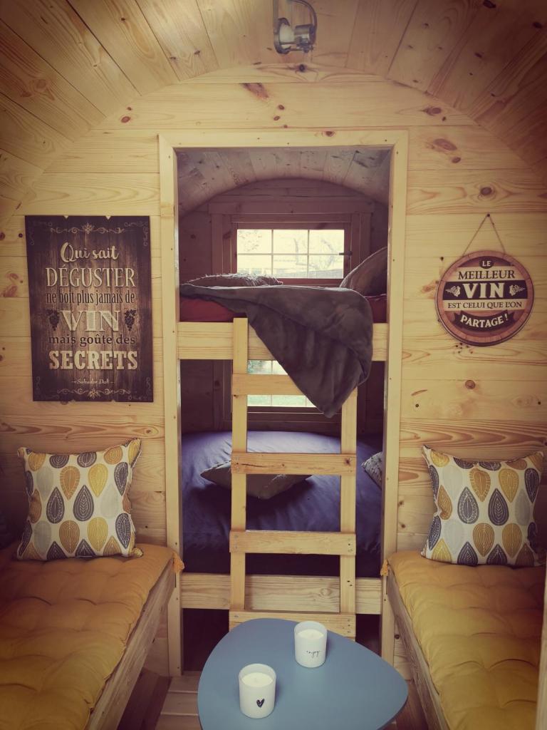 - une chambre avec des lits superposés et une échelle dans une cabine dans l'établissement sublime tonneau avec spa sous bulle privatif, à Lanthenay
