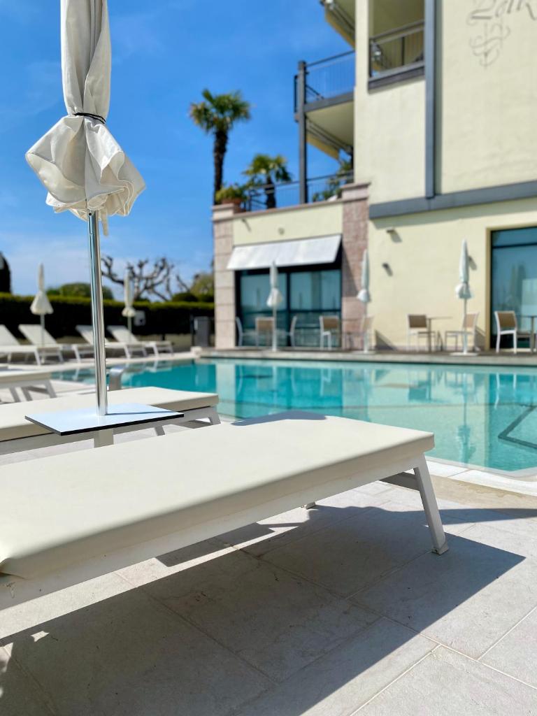 un banc blanc devant une piscine dans l'établissement Hotel Villa Letizia, à Bardolino