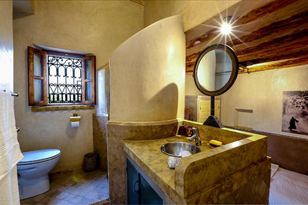 une salle de bain avec un lavabo, des toilettes et un miroir dans l'établissement Riad 92 - Architect's Riad in the Exclusive Dar El Bacha, à Marrakech 33 autres photos
