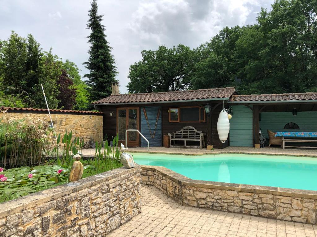 une maison avec une piscine dans une cour dans l'établissement le bon chemin roulotte, à Fage