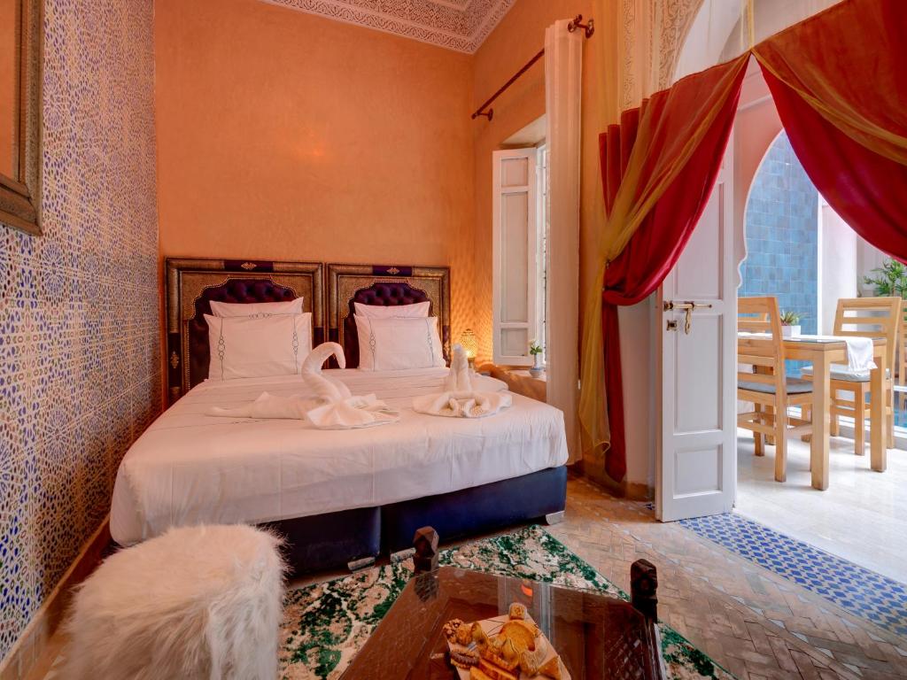 une chambre avec un lit avec des draps blancs et une fenêtre dans l'établissement Riad Princesse Du Désert & Spa, à Marrakech