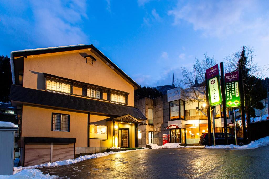 un bâtiment avec une enseigne sur le côté d'une rue dans l'établissement Oyado Hisaya, à Kami