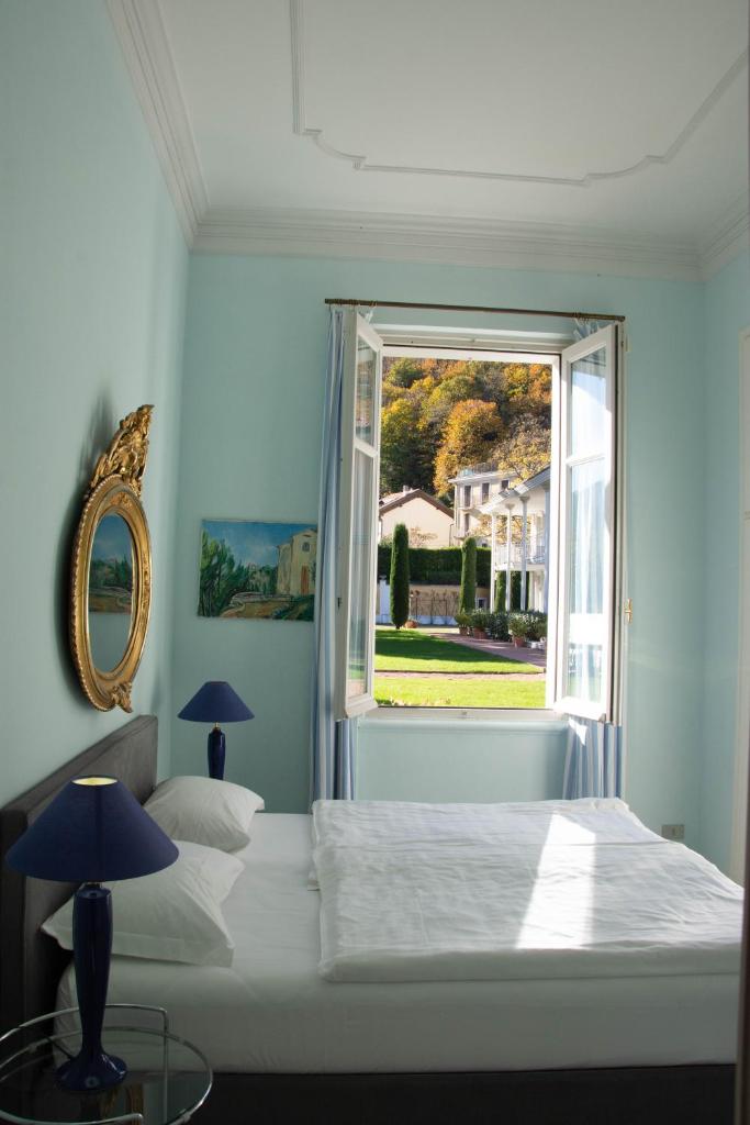 une chambre avec un lit blanc et une fenêtre dans l'établissement Residence Ville Lago Lugano, à Porto Ceresio
