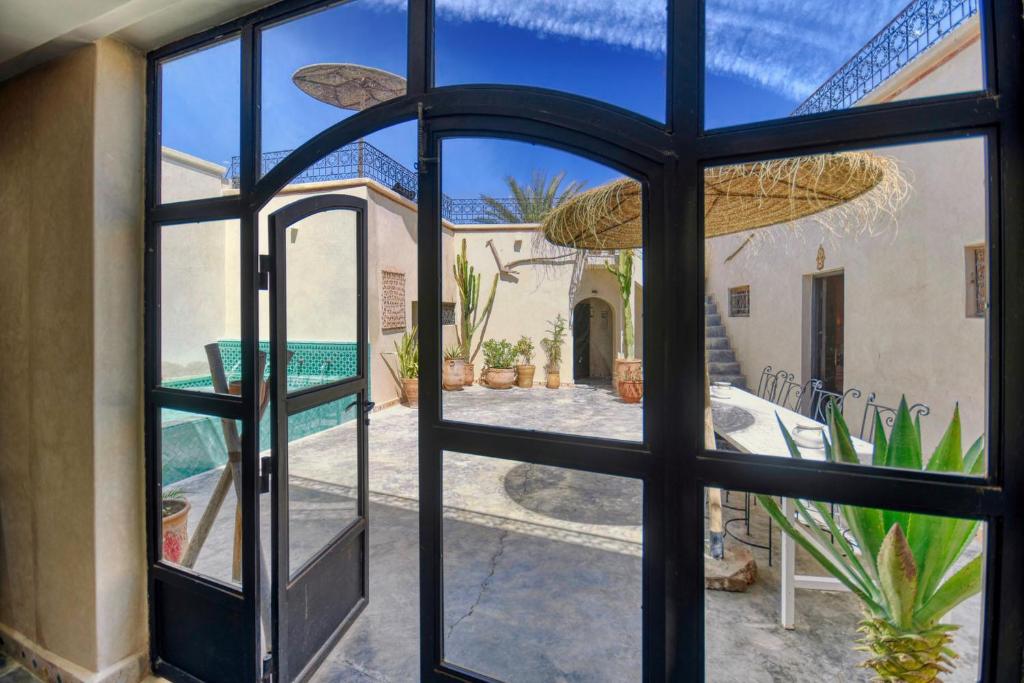 - une vue sur la cour depuis une porte en verre dans l'établissement Riad Amazine - Piscine - Rooftop - 6 or 7 Px, à Agadir