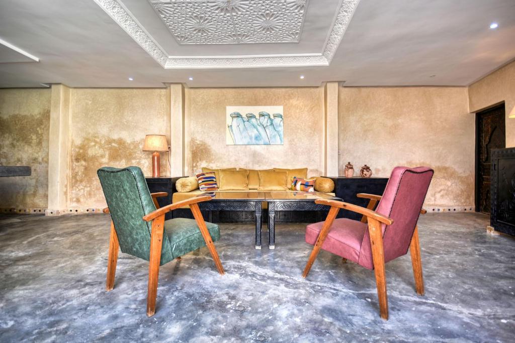 un salon avec une table et deux chaises dans l'établissement Riad Amazine - Piscine - Rooftop - 6 or 7 Px, à Agadir