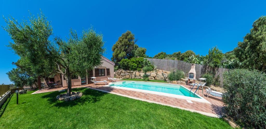 une cour avec une piscine et une cour avec de l'herbe verte dans l'établissement Villa Ara, à Torre delle Stelle