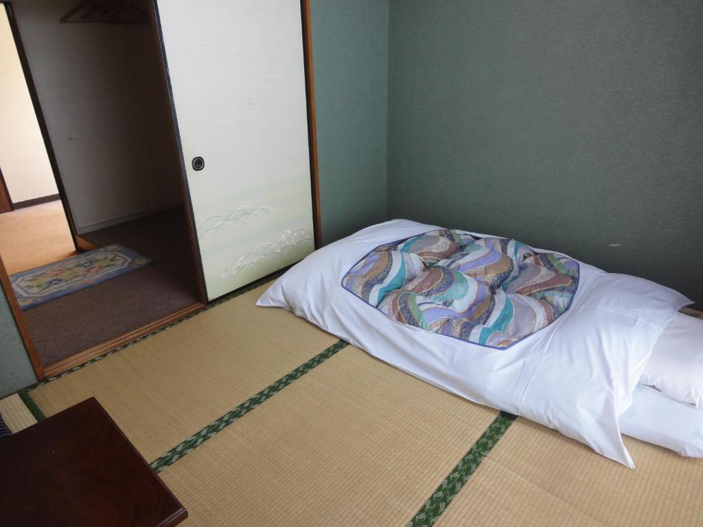 un lit dans un coin d'une pièce dans l'établissement Hotel Sankyu, à Tsukuba 17 autres photos