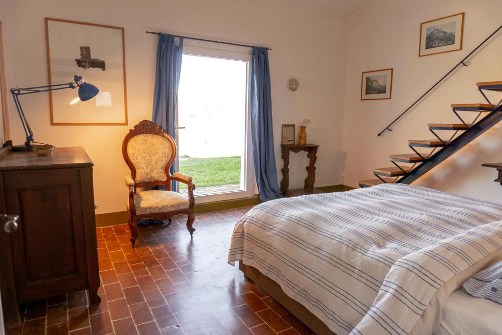 - une chambre avec un lit, une chaise et un escalier dans l'établissement Casale Le Pietre, à Marta 86 autres photos