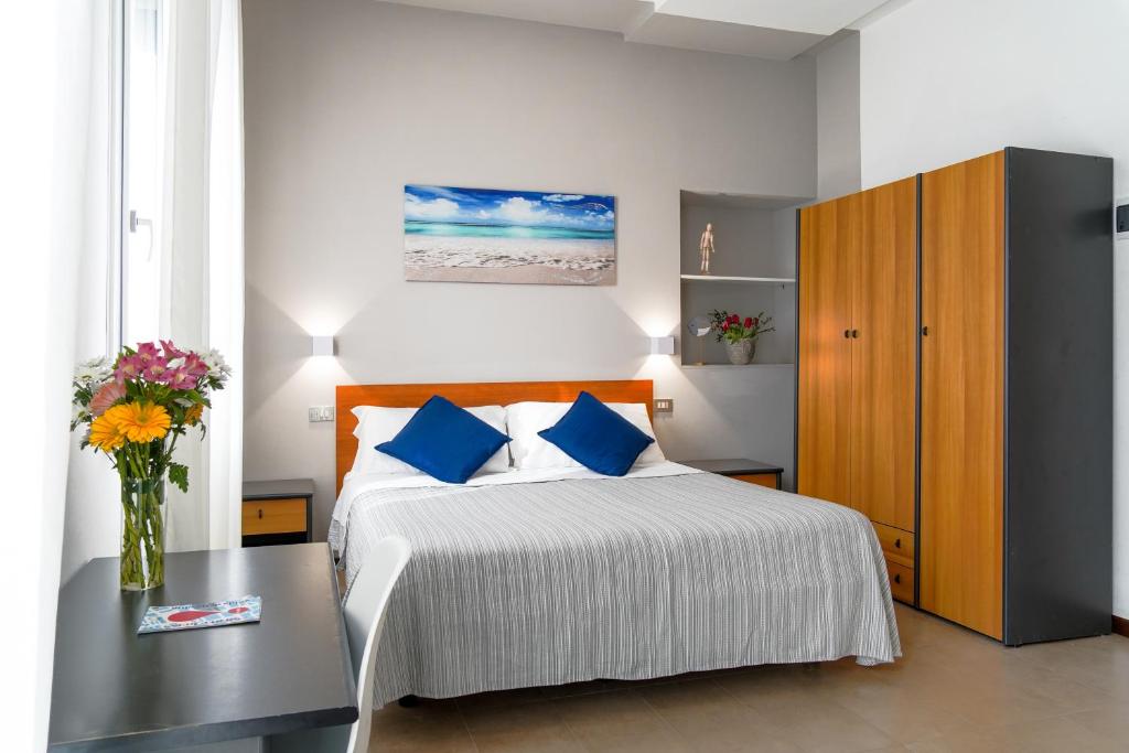 une chambre avec un lit et un vase de fleurs sur une table dans l'établissement Hotel Mon Pays, à Rimini 34 autres photos
