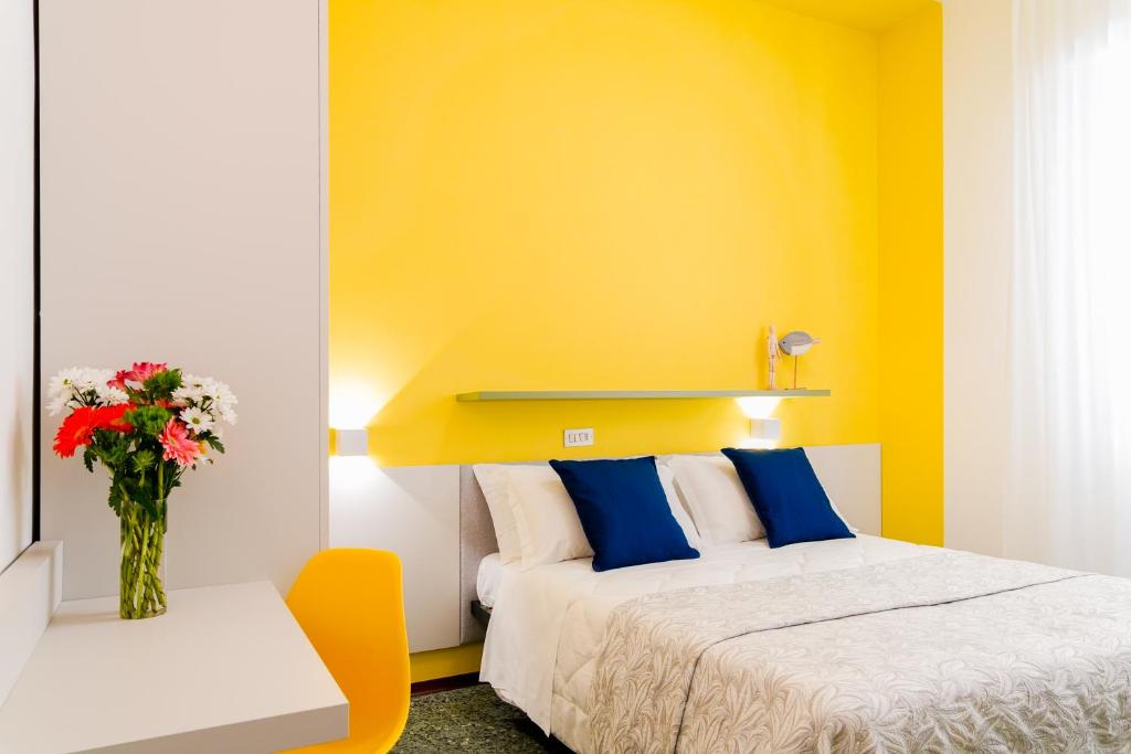 - une chambre avec un lit et un vase de fleurs dans l'établissement Hotel Mon Pays, à Rimini