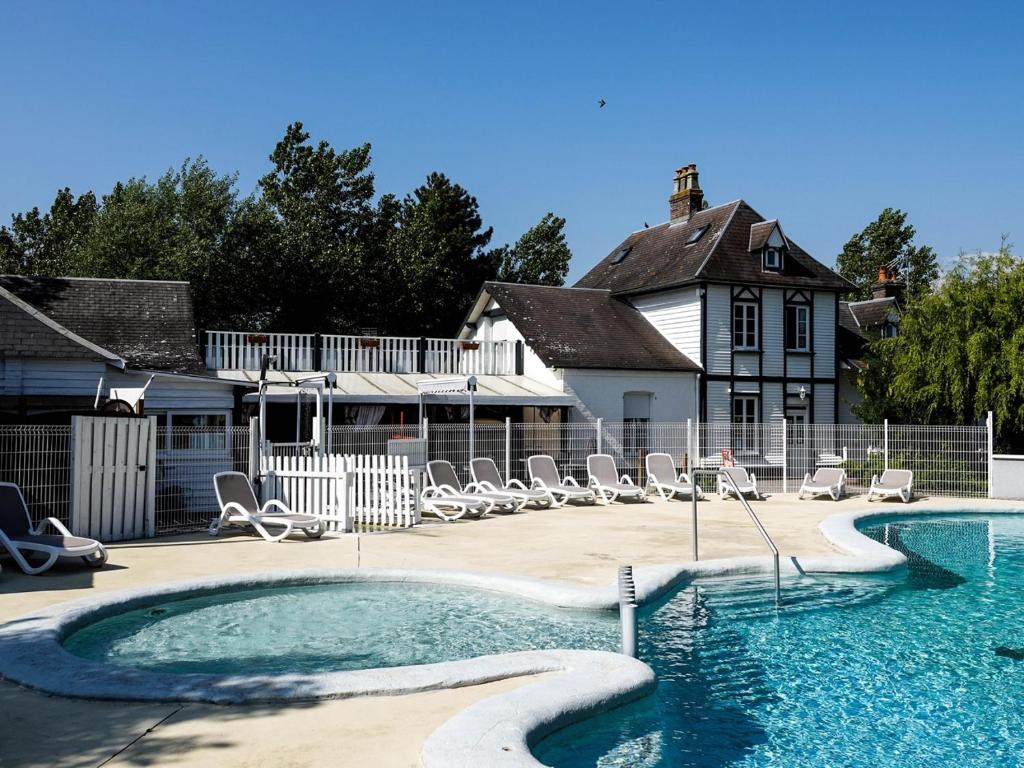 une piscine avec des chaises et une maison dans l'établissement Camping les 3 Sablières, à Saint-Firmin