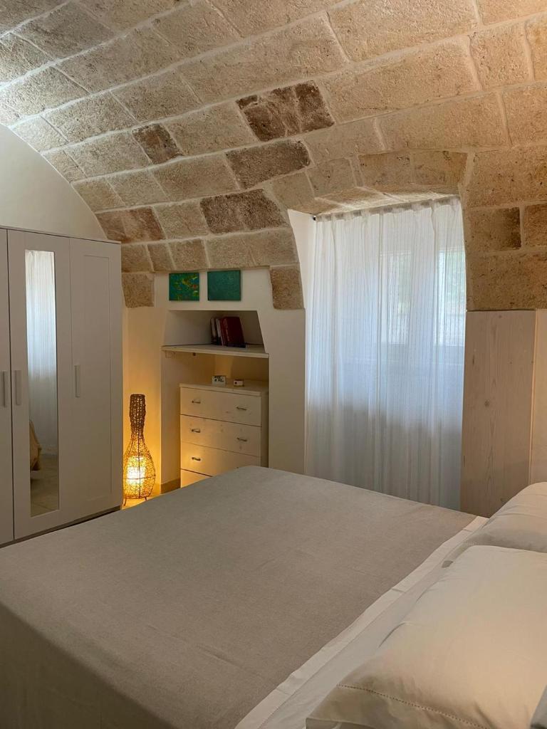 - une chambre avec un lit et un plafond en pierre dans l'établissement Il Vecchio Carrubo - Villa con piscina a sfioro, à Macchia di Monte