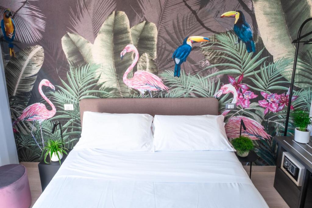 - une chambre avec un lit orné d'une fresque murale de flamants roses dans l'établissement Lilium Maris Hotel, à Bibione