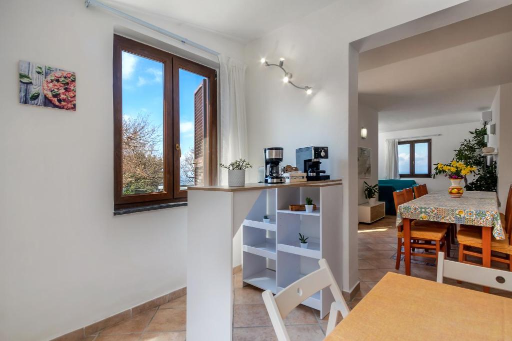 une cuisine et une salle à manger avec une table et une fenêtre dans l'établissement Villa Novanta, à Massa Lubrense
