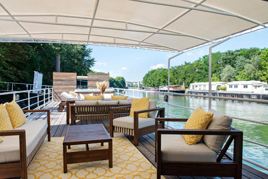 un pont sur un bateau avec des chaises et des tables dans l'établissement Escale Sur Seine, à Paris