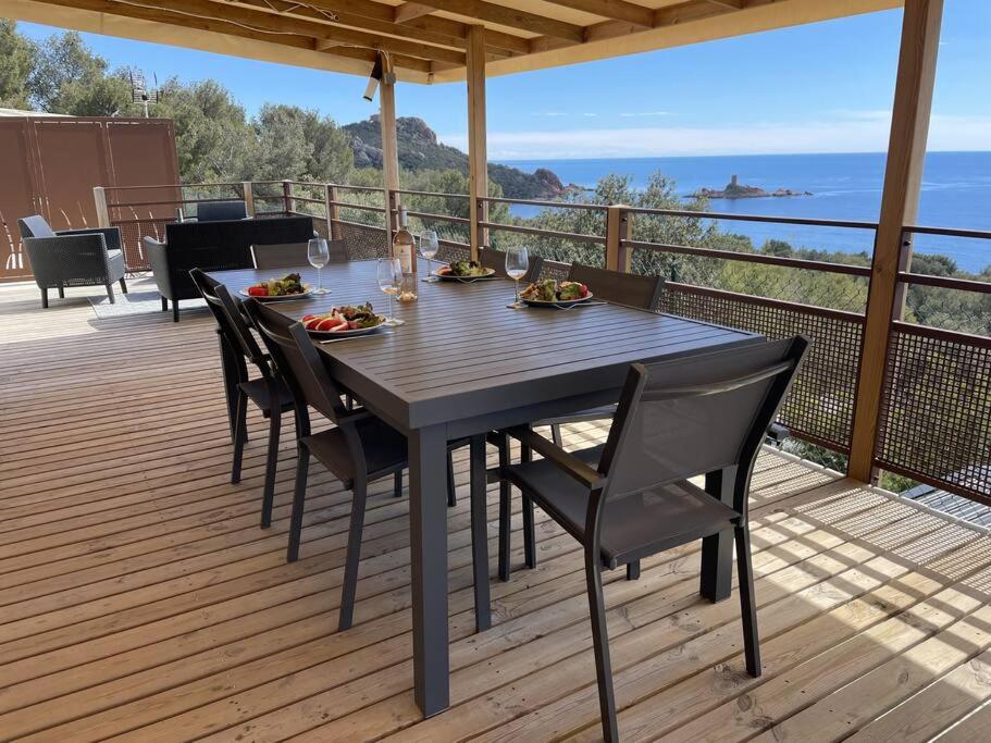 une terrasse en bois avec une table et des chaises dessus dans l'établissement Blue Horizon, à Saint-Raphaël