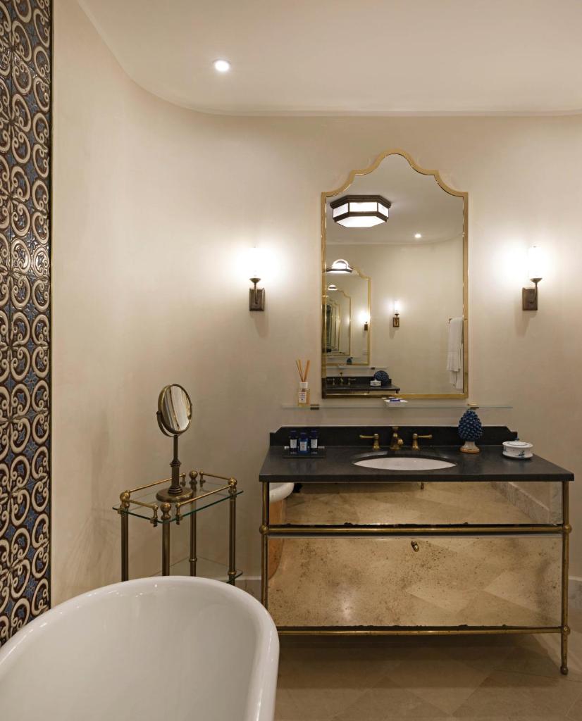 une salle de bain avec une baignoire, un lavabo et un miroir dans l'établissement Villa Sant'Andrea, A Belmond Hotel, Taormina Mare, à Taormine 105 autres photos