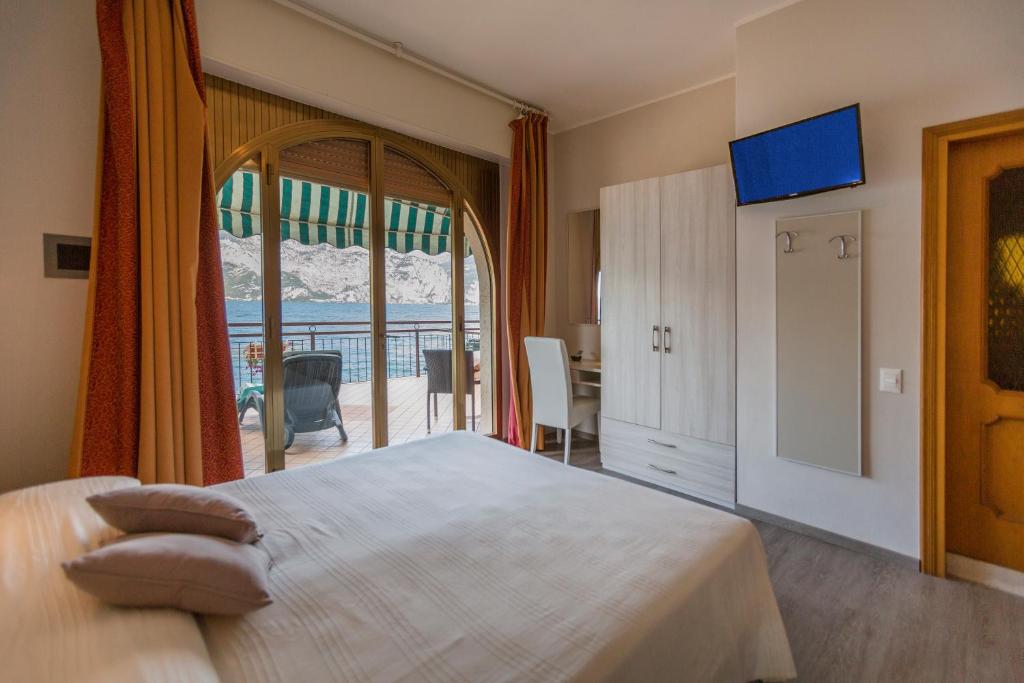 une chambre avec un grand lit et une grande fenêtre dans l'établissement Hotel Nettuno, à Brenzone
