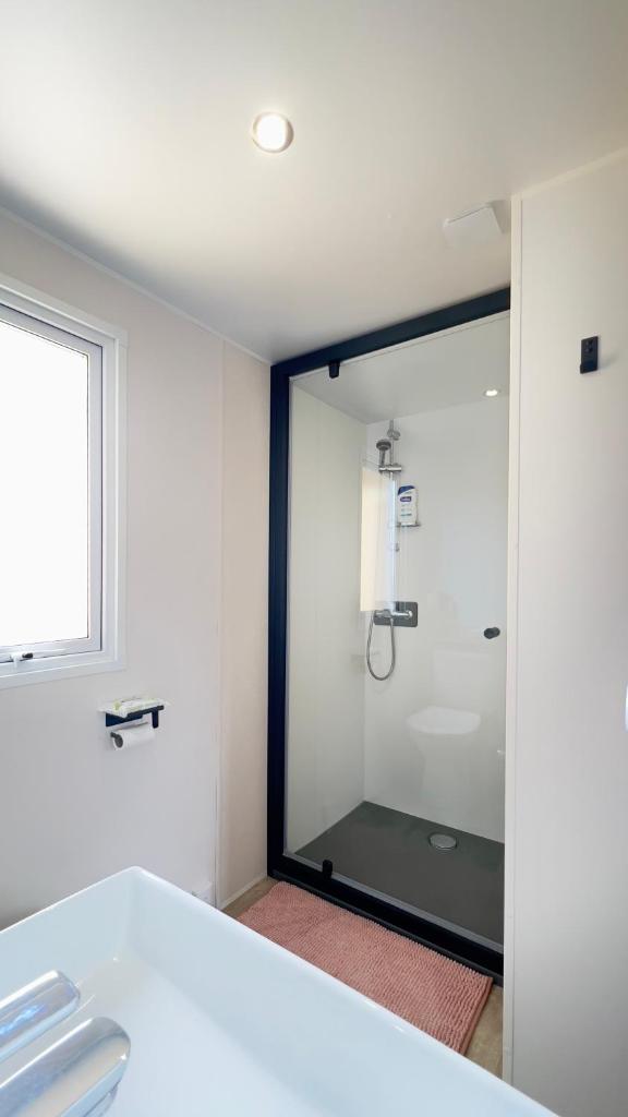 une salle de bain avec une douche avec une porte vitrée dans l'établissement L'incontournable Tout Confort Camping Siblu, à Fréjus 36 autres photos