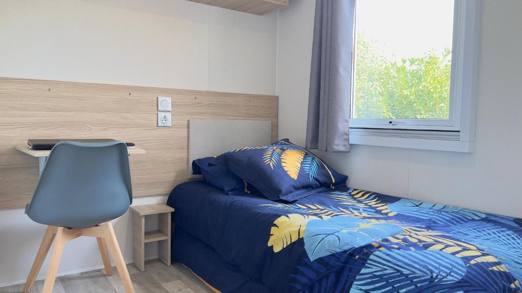 une chambre avec un lit, un bureau et une chaise dans l'établissement L'incontournable Tout Confort Camping Siblu, à Fréjus