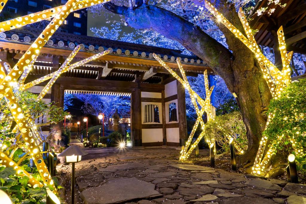 - un jardin avec des lumières de Noël en face d'un bâtiment dans l'établissement Takanawa Hanakohro - in Grand Prince Hotel Takanawa, à Tokyo