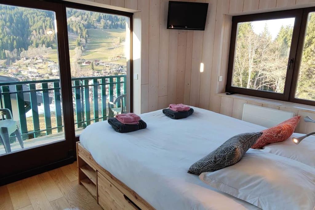 une chambre avec un lit et une grande fenêtre dans l'établissement Apartment Grizzly - 2 bedrooms - Ski in/out- Les Gets, aux Gets