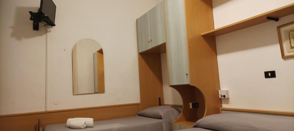 une chambre avec deux lits et un miroir dans l'établissement Villa Lavinia, à Rimini