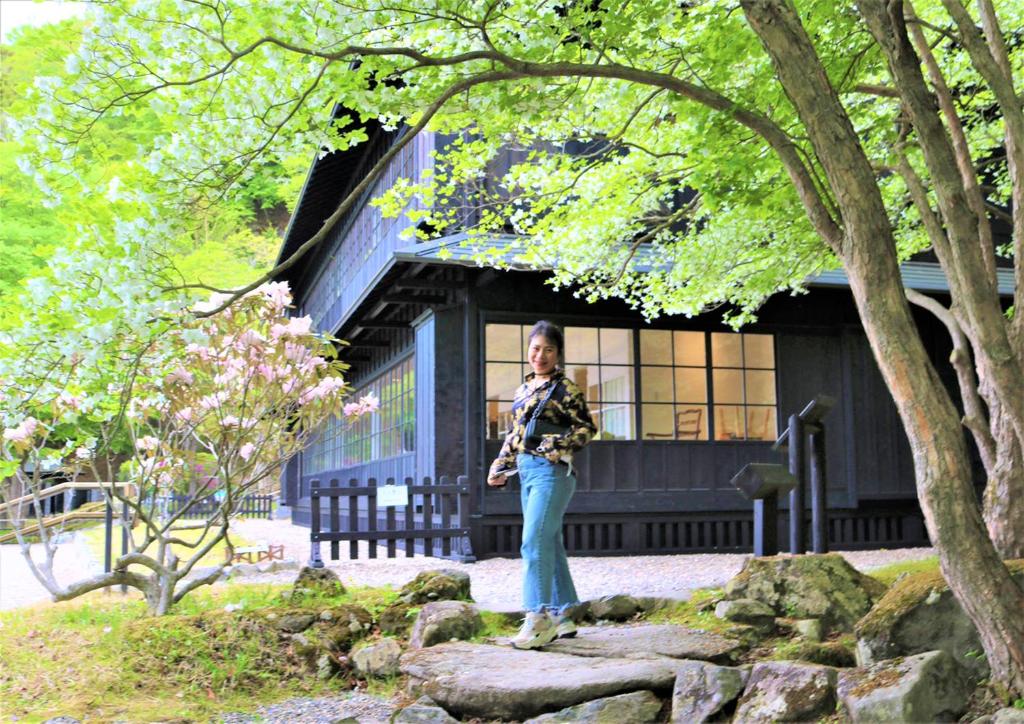 une femme debout sur des rochers devant un bâtiment dans l'établissement Hatago Nagomi, à Nikkō